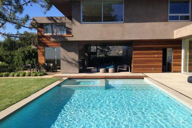 Inspiration for a mid-sized contemporary backyard concrete and rectangular pool remodel in Los Angeles