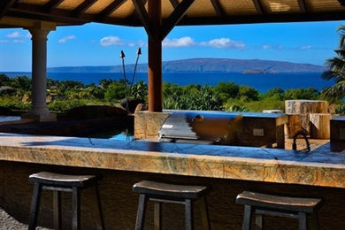 Inspiration for a large timeless backyard stone patio remodel in Hawaii with a roof extension