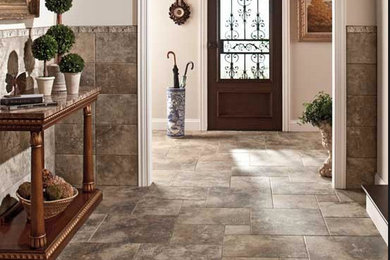 Photo of a mid-sized contemporary entry hall in Tampa with beige walls, travertine floors, a single front door, a dark wood front door and grey floor.