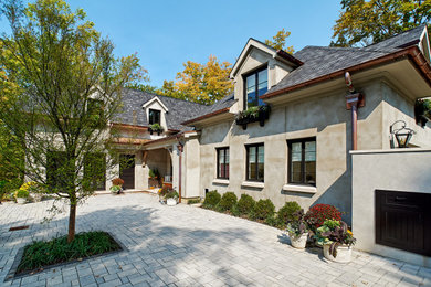 Traditional beige two-story stucco house exterior idea in Cincinnati with a hip roof, a shingle roof and a gray roof