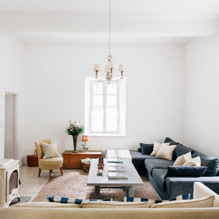 Imagen de salón cerrado, mediterráneo, grande, sin televisor, con paredes blancas, suelo de baldosas de cerámica, estufa de leña y marco de chimenea de metal