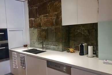 Inspiration for an industrial kitchen in Sydney with an undermount sink and glass sheet splashback.