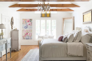 Large transitional master medium tone wood floor, brown floor and vaulted ceiling bedroom photo in Nashville with white walls