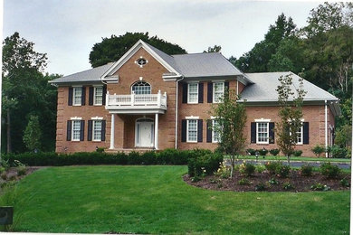 Huge traditional red two-story brick exterior home idea in New York with a hip roof
