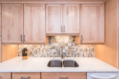 Eat-in kitchen - mid-sized transitional l-shaped vinyl floor and beige floor eat-in kitchen idea in DC Metro with a double-bowl sink, shaker cabinets, light wood cabinets, quartzite countertops, gray backsplash, stone tile backsplash, stainless steel appliances and a peninsula