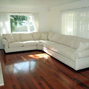 Foto de salón para visitas cerrado, mediterráneo, de tamaño medio, con paredes blancas, suelo de madera en tonos medios, chimenea tradicional, marco de chimenea de baldosas y/o azulejos y pared multimedia