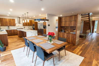 This is an example of a large contemporary u-shaped open plan kitchen in Edmonton with a double-bowl sink, flat-panel cabinets, medium wood cabinets, marble benchtops, grey splashback, matchstick tile splashback, stainless steel appliances, medium hardwood floors and with island.