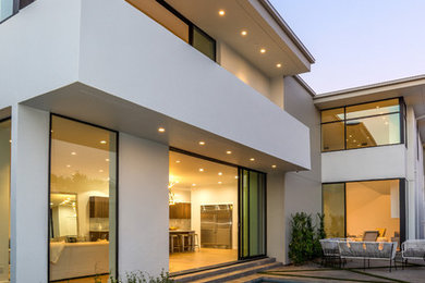 Large modern white two-story stucco flat roof idea in Los Angeles