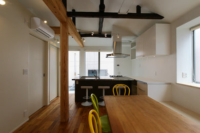Photo of a mid-sized modern open plan dining in Tokyo with white walls, medium hardwood floors and brown floor.