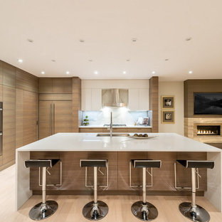 Offene, Große Moderne Küche in L-Form mit Unterbauwaschbecken, flächenbündigen Schrankfronten, hellen Holzschränken, Mineralwerkstoff-Arbeitsplatte, Küchenrückwand in Weiß, Rückwand aus Stein, Küchengeräten aus Edelstahl, hellem Holzboden und Kücheninsel in Vancouver