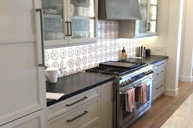 Inspiration for a transitional kitchen pantry remodel in Orange County with multicolored backsplash and an island