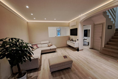 Ispirazione per un soggiorno design di medie dimensioni e chiuso con sala formale, pareti beige, pavimento in gres porcellanato, TV a parete e soffitto ribassato
