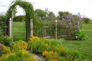 Photo of a large traditional full sun backyard mulch landscaping in Other.