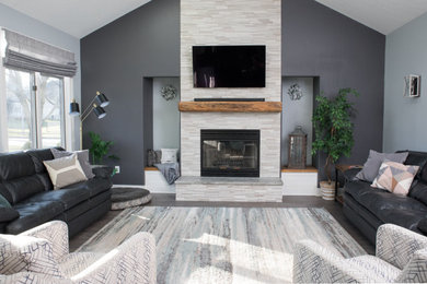 Inspiration for a large rustic open concept dark wood floor and multicolored floor family room remodel in Other with gray walls, a standard fireplace, a stone fireplace and a wall-mounted tv
