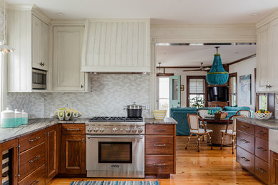 Large beach style galley eat-in kitchen in Boston with a farmhouse sink, flat-panel cabinets, medium wood cabinets, marble benchtops, beige splashback, glass tile splashback, stainless steel appliances, medium hardwood floors, no island and beige benchtop.