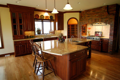 Inspiration for a mid-sized timeless u-shaped light wood floor open concept kitchen remodel in Other with an undermount sink, raised-panel cabinets, medium tone wood cabinets, granite countertops, stainless steel appliances and an island