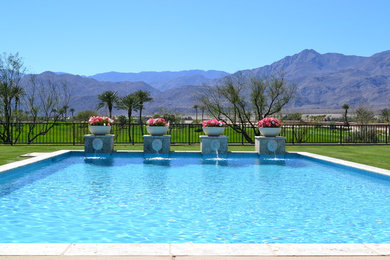 Example of a large trendy backyard stone and rectangular lap pool fountain design in Los Angeles