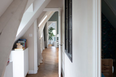 Idée de décoration pour un couloir champêtre de taille moyenne avec un mur beige, parquet clair et poutres apparentes.