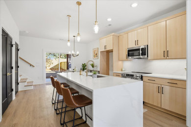 Inspiration for a huge modern single-wall eat-in kitchen remodel in DC Metro with a drop-in sink, flat-panel cabinets, quartz countertops, white backsplash, quartz backsplash, stainless steel appliances, an island and white countertops