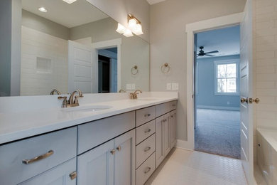 Mid-sized transitional 3/4 bathroom in Nashville with recessed-panel cabinets, grey cabinets, an alcove tub, a shower/bathtub combo, white tile, ceramic tile, grey walls, ceramic floors, an undermount sink, engineered quartz benchtops, white floor, a shower curtain and white benchtops.