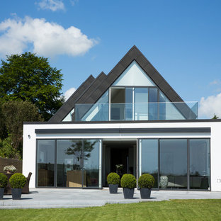 Idéer för att renovera ett mellanstort funkis vitt stenhus, med två våningar och valmat tak