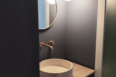 Ispirazione per un piccolo bagno di servizio contemporaneo con ante lisce, ante in legno chiaro, pareti blu, pavimento in gres porcellanato, lavabo a bacinella, top in legno, pavimento marrone, mobile bagno freestanding e soffitto ribassato