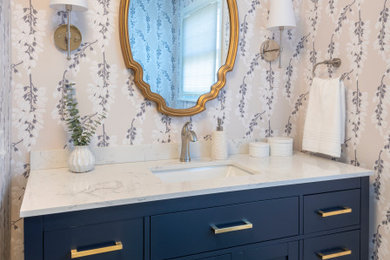 Inspiration for a medium sized bathroom in Providence with blue cabinets, white walls, porcelain flooring, a submerged sink, engineered stone worktops, grey floors, white worktops, a single sink, a freestanding vanity unit and wallpapered walls.