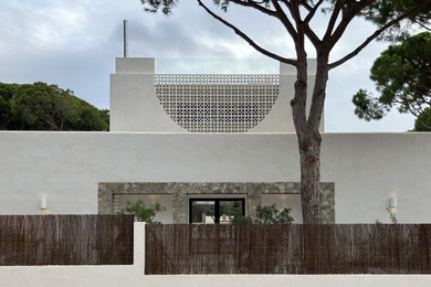 Inspiration for a contemporary white two-story house exterior remodel in Other with a tile roof