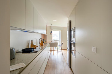Estrecha y funcional: una cocina blanca con barra de madera