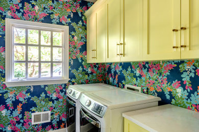 Mid-sized eclectic galley porcelain tile, gray floor and wallpaper utility room photo in Other with shaker cabinets, quartz countertops, blue walls, a side-by-side washer/dryer and white countertops