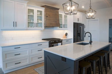 Kitchen - cottage galley kitchen idea in Other with a drop-in sink, quartzite countertops, white backsplash, ceramic backsplash, black appliances and white countertops