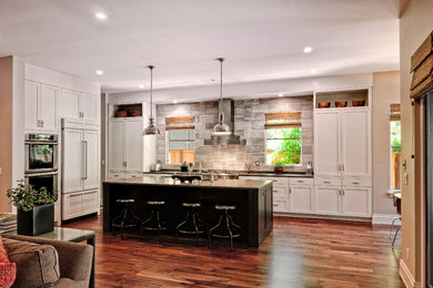 Open concept kitchen - mid-sized transitional l-shaped medium tone wood floor open concept kitchen idea in Denver with shaker cabinets, white cabinets, gray backsplash, paneled appliances and an island