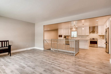 Kitchen - contemporary l-shaped porcelain tile and gray floor kitchen idea in Denver with a farmhouse sink, shaker cabinets, white cabinets, quartzite countertops, gray backsplash, ceramic backsplash, stainless steel appliances, an island and white countertops