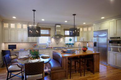 Example of a large classic medium tone wood floor eat-in kitchen design in Charleston with a double-bowl sink, shaker cabinets, white cabinets, granite countertops, multicolored backsplash, glass tile backsplash, stainless steel appliances and an island