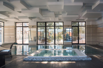 Esempio di una grande piscina coperta a sfioro infinito design rettangolare con una vasca idromassaggio e piastrelle