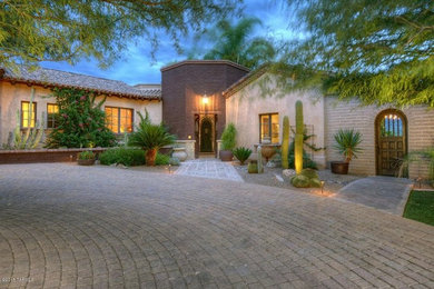 Example of a mid-sized mountain style beige one-story adobe gable roof design in Phoenix