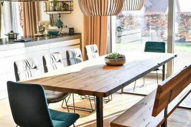 Offenes, Geräumiges Modernes Esszimmer mit hellem Holzboden und braunem Boden in Nürnberg