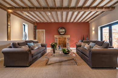 Photo of a large modern living room in West Midlands with pink walls, carpet, a standard fireplace, a brick fireplace surround and beige floors.