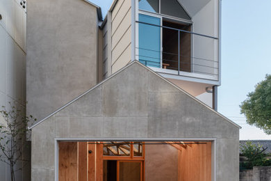 Foto de fachada de casa gris y gris actual pequeña a niveles con revestimiento de aglomerado de cemento, tejado a dos aguas, tejado de metal y tablilla