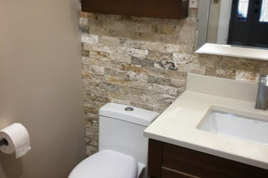 Example of a small trendy beige tile and stone slab ceramic tile and beige floor bathroom design in Ottawa with shaker cabinets, medium tone wood cabinets, a one-piece toilet, beige walls, an undermount sink and quartz countertops