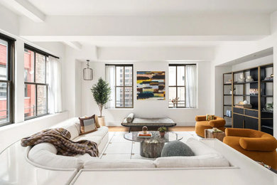 Living room - large modern loft-style light wood floor and exposed beam living room idea in New York with white walls