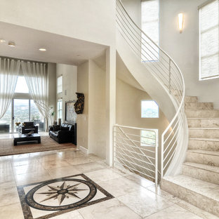 Design ideas for a medium sized modern curved metal railing staircase in Orange County with limestone treads and limestone risers.
