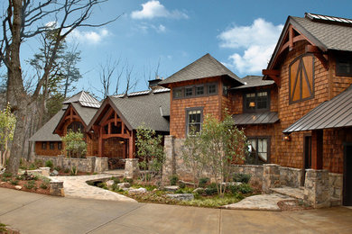 This is an example of a large contemporary two-storey house exterior in Denver with wood siding, a gable roof and a shingle roof.