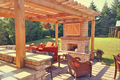 Large country backyard patio in Cincinnati with a fire feature, concrete pavers and a pergola.