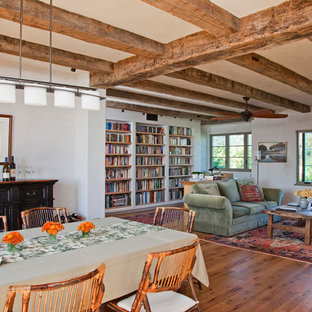 Modelo de biblioteca en casa abierta, mediterránea, de tamaño medio, con paredes blancas y suelo de madera en tonos medios