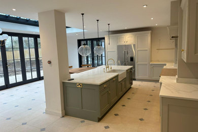 Inspiration for an expansive victorian l-shaped open plan kitchen in Buckinghamshire with an integrated sink, marble worktops, stainless steel appliances, ceramic flooring, an island, beige worktops and feature lighting.