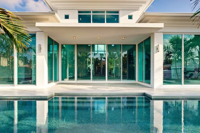 This is an example of a contemporary one-storey glass exterior in Miami.