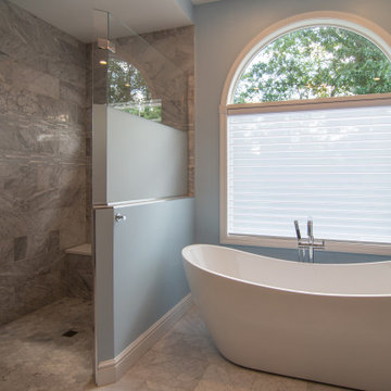 Traditional master bath utilizing frosted and clear glass to allow for needed pr