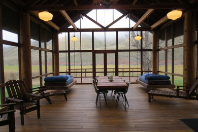 Inspiration for a mid-sized rustic screened-in back porch remodel in Boise with decking