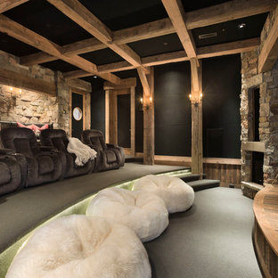 This is an example of a rustic home cinema in Other with black walls and carpet.